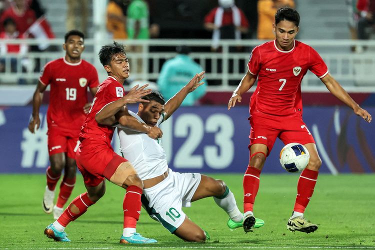 Bek Indonesia (12) Pratama Arhan menjaga gelandang Irak Nihad Mohammed untuk memperebutkan bola pada pertandingan perebutan tempat ketiga Piala Asia U23 AFC Qatar 2024 antara Irak vs Indonesia di Stadion Abdullah Bin Khalifa di Doha pada 2 Mei 2024. (Foto oleh Karim JAAFAR / AFP)